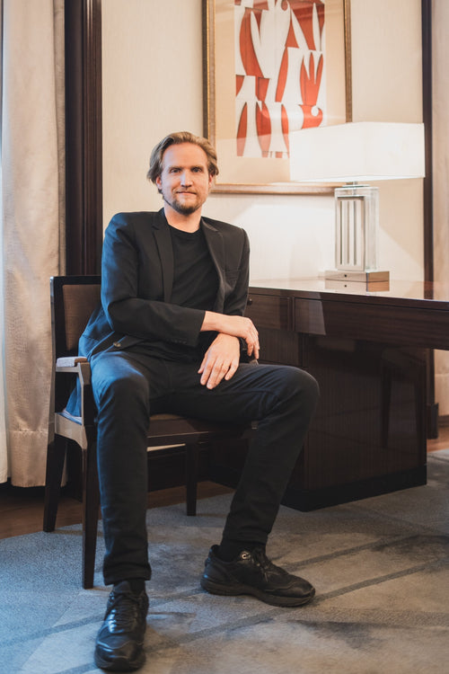 David Tomaszewski assis sur une chaise les bras croisés 