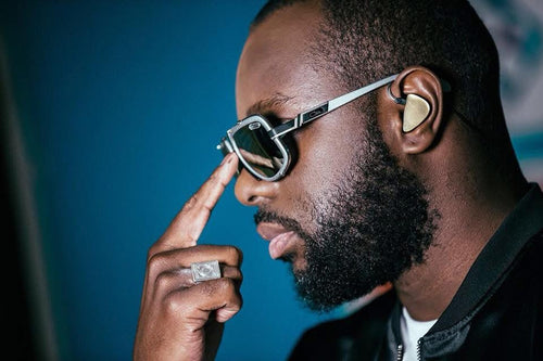 Photo de Gims qui redresse ses lunettes, de profil