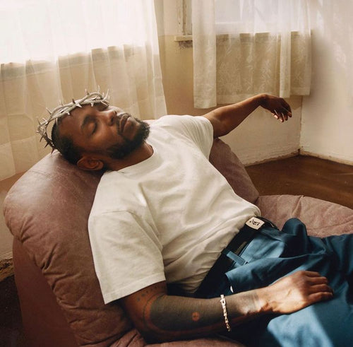 Kendrick Lamar allongé sur un fauteuil avec une couronne d'épine sur la tête