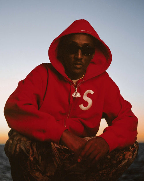 Le rappeur Steban à genou avec une capuche