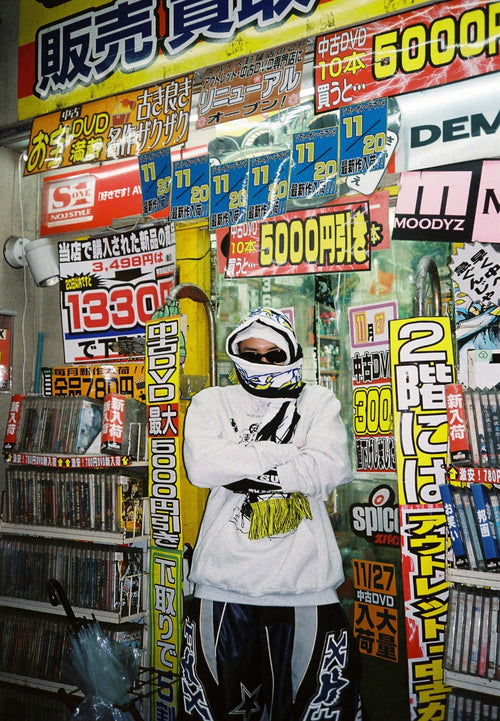 Le rappeur japonais Vava pris en photo dans une rue de Tokyo avec une écharpe et des lunettes de soleil